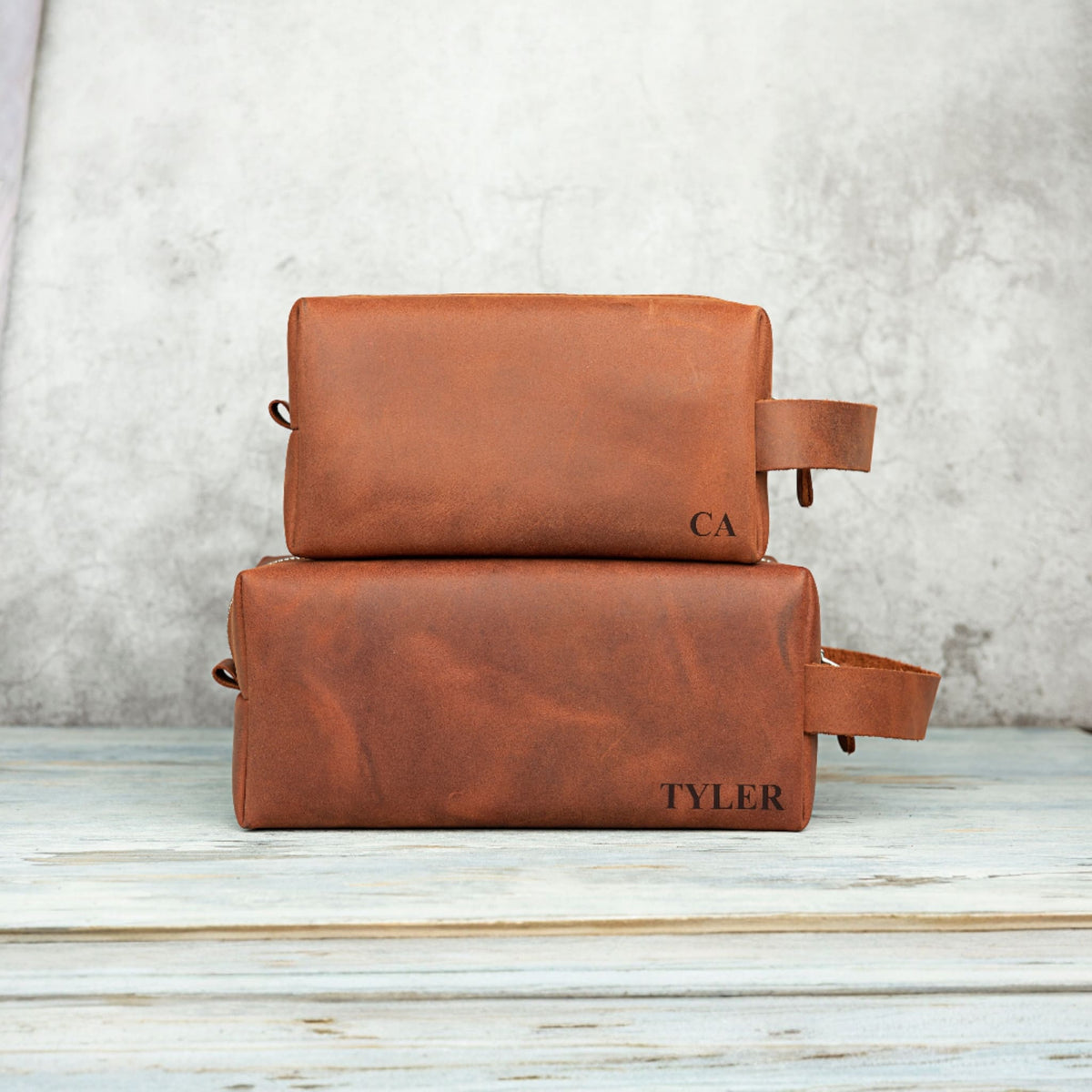 Two leather dopp kits engraved with CA and TYLER