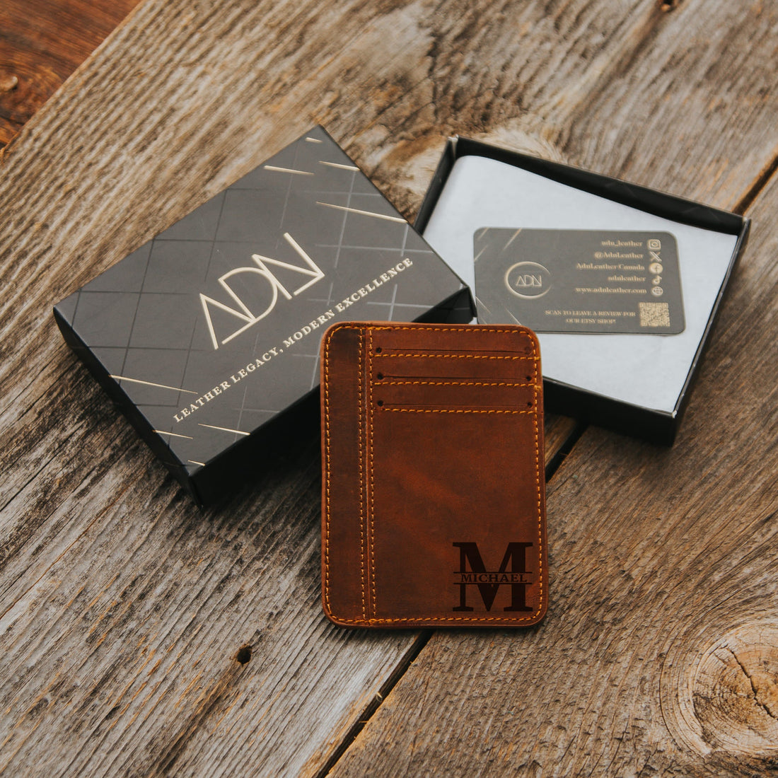 Leather card holder engraved with an M monogram beside an ADN Leather gift box