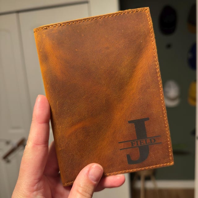 Customer photo: tan leather passport holder engraved with a J monogram