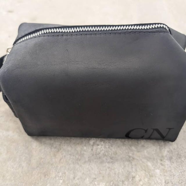 Customer photo: black leather toiletry bag engraved with the initials CN